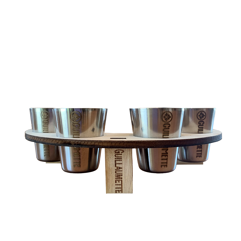 Set de 4 verres inox gravés Guillaumette, parfaitement maintenus dans un support en bois circulaire également marqué du logo. L’ensemble reflète un savoir-faire artisanal et une esthétique élégante pour des dégustations conviviales.