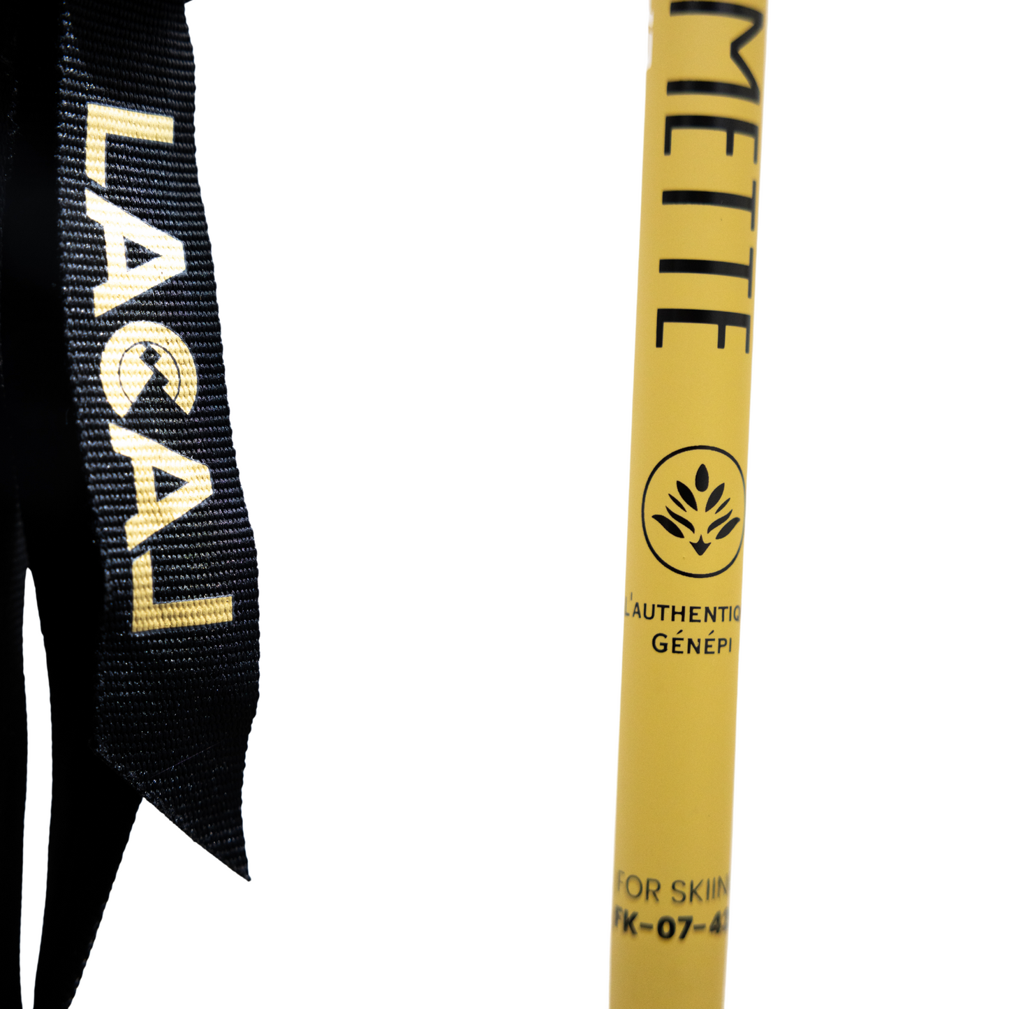 Zoom sur le bâton Lacal x Guillaumette montrant la dragonne avec le logo Lacal et le marquage "L’Authentique Génépi" sur le bâton.