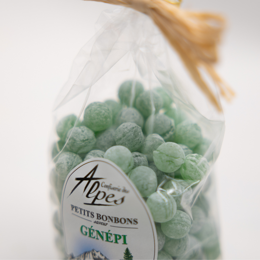 Gros plan sur un sachet de perlettes vertes au génépi de la Confiserie des Alpes, montrant les détails du bonbon et de l’étiquette.