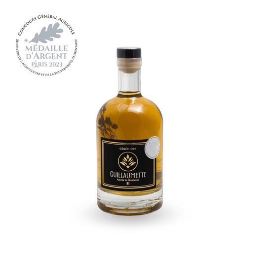 Bouteille de 70cl de Génépi Dry Guillaumette, fleurs de montagne visibles dans la liqueur, médaille d’argent 2023, étiquette noire et dorée