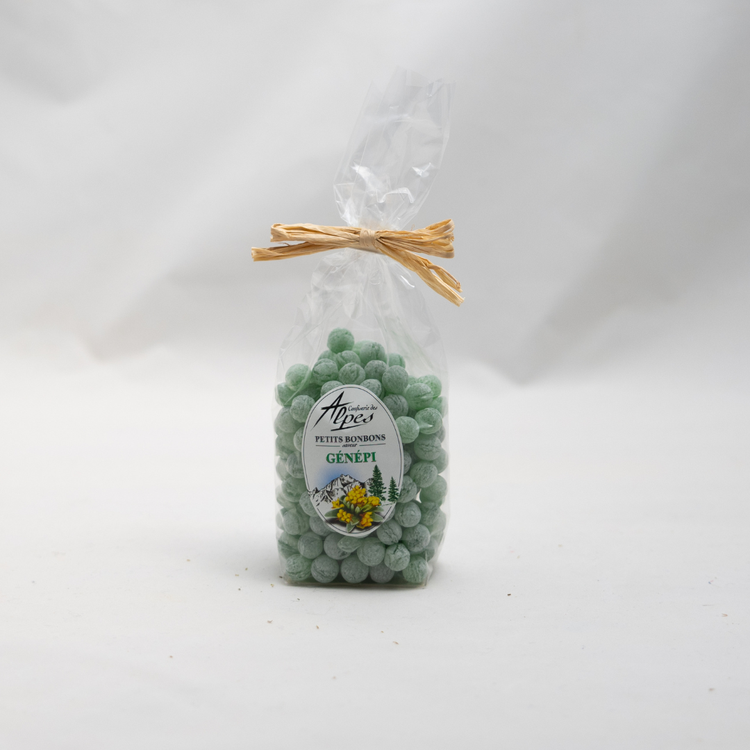 Sachet transparent de petites perles vertes au génépi, appelées perlettes, confectionnées par la Confiserie des Alpes, avec un nœud en raphia naturel.