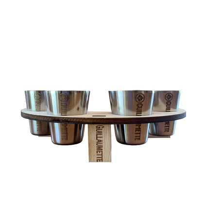 Set de 4 verres inox gravés Guillaumette, parfaitement maintenus dans un support en bois circulaire également marqué du logo. L’ensemble reflète un savoir-faire artisanal et une esthétique élégante pour des dégustations conviviales.