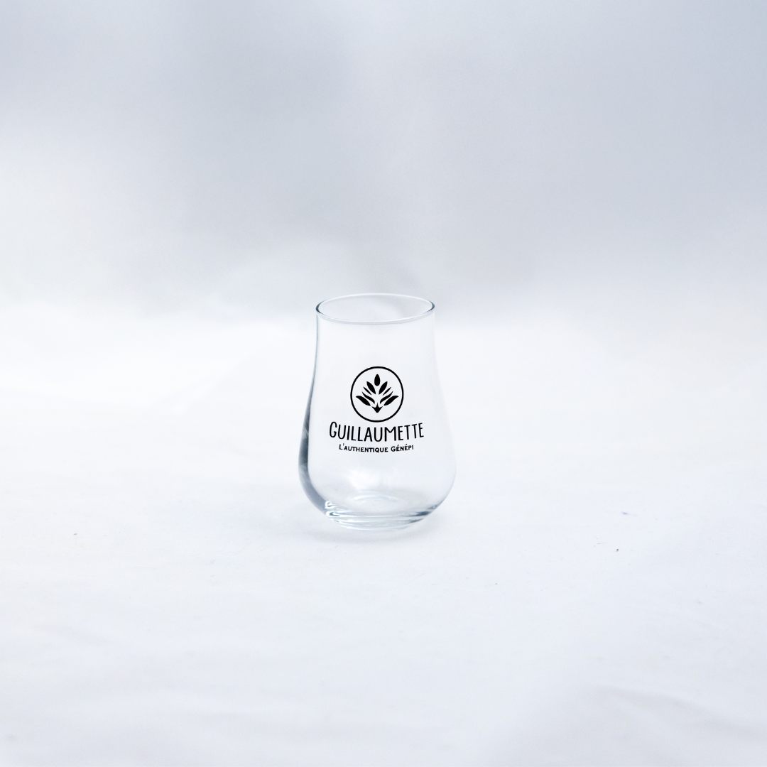 Verre à liqueur galbé transparent avec le logo Guillaumette et l’inscription « L’authentique Génépi », présenté sur fond blanc.